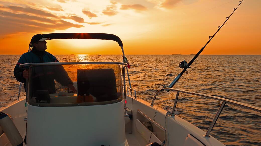 Angler setting out on a fishing boat at sunrise